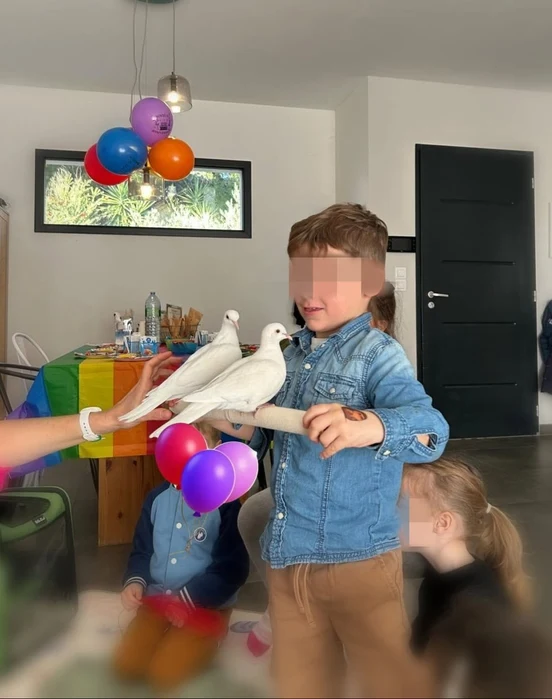 Enfant tenant les colombes Tic & Toc lors d'un anniversaire
